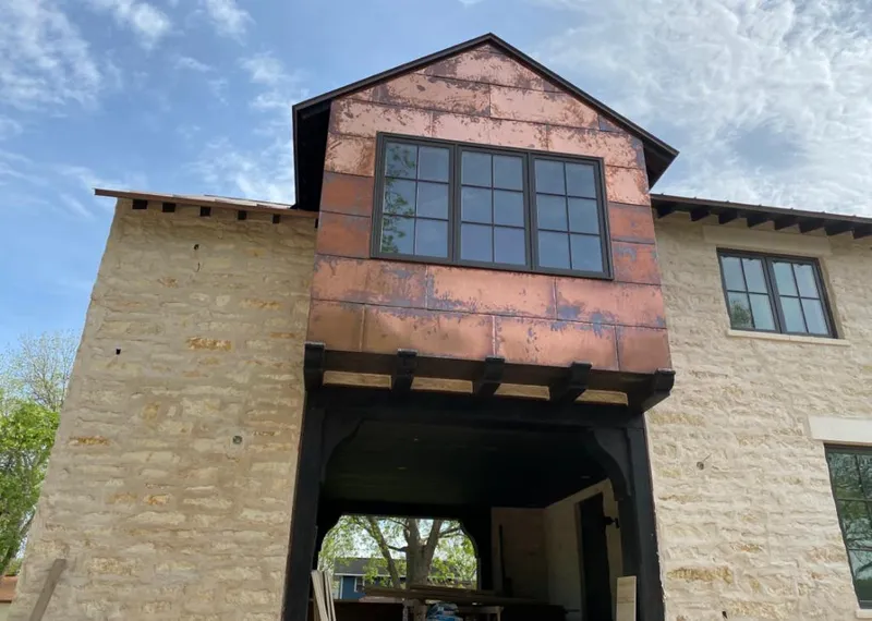 Copper metal panel facade on a stone building for Metal Roof Coating in Cambria